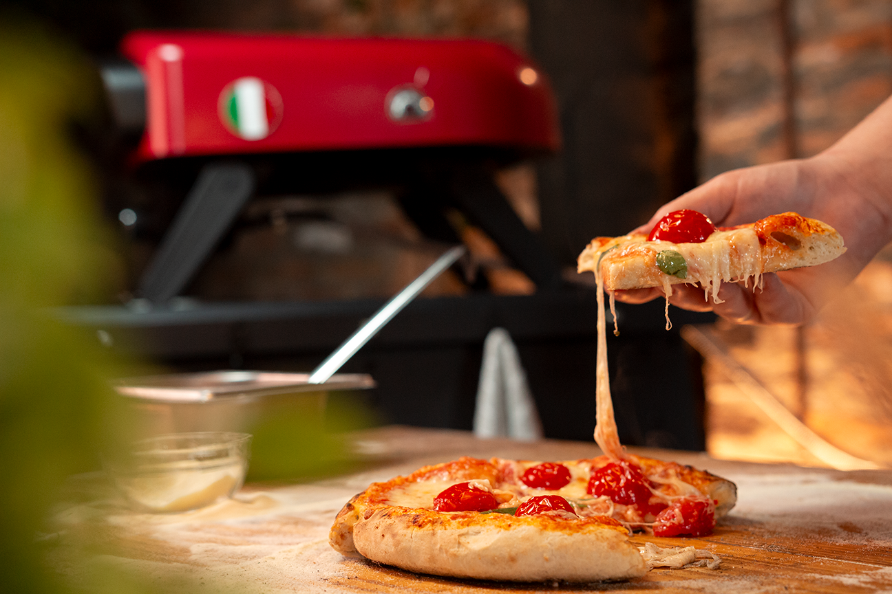 Fotografia dos Fornos Nino Malta e Napoli sendo utilizados em uma cozinha para o preparo de pizzas.