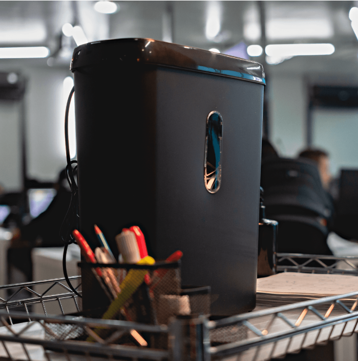 Fotografias da Fragmentadora de Papel COSM 11 SC fragmentando papéis e um CD, representando máquinas para papelaria.