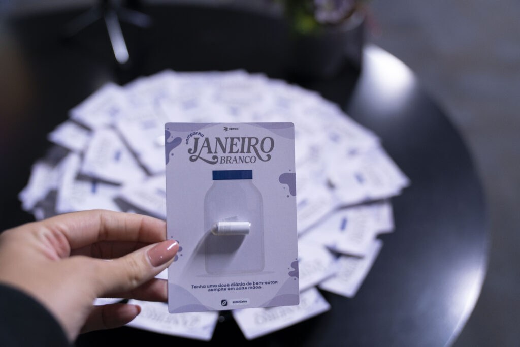 Fotografias da palestrante, do cartão com a identidade visual da campanha Janeiro Branco e de um papel com uma frase motivacional.