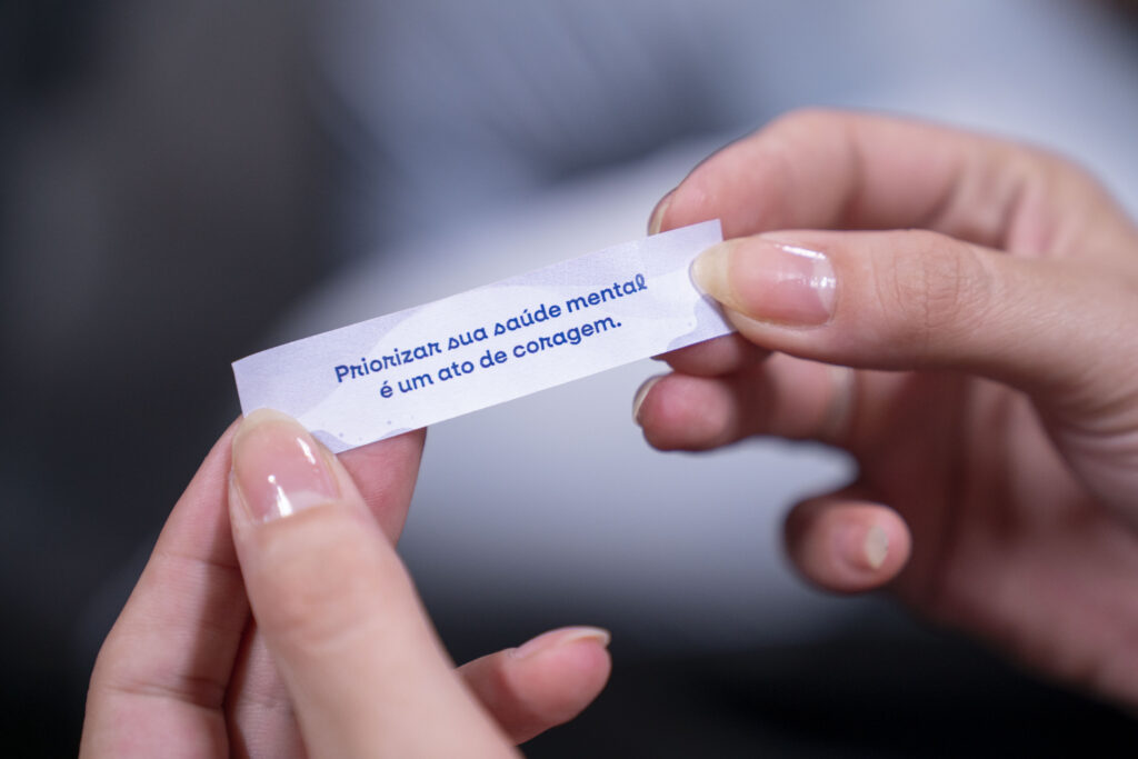 Fotografias da palestrante, do cartão com a identidade visual da campanha Janeiro Branco e de um papel com uma frase motivacional.