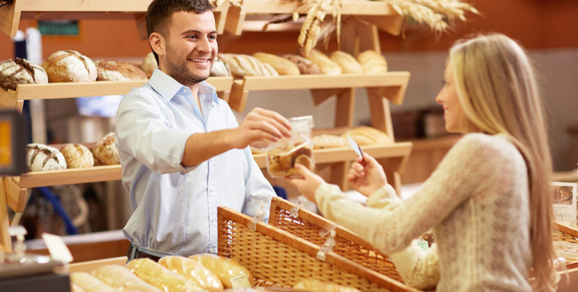 mulher comprando pães em uma padaria