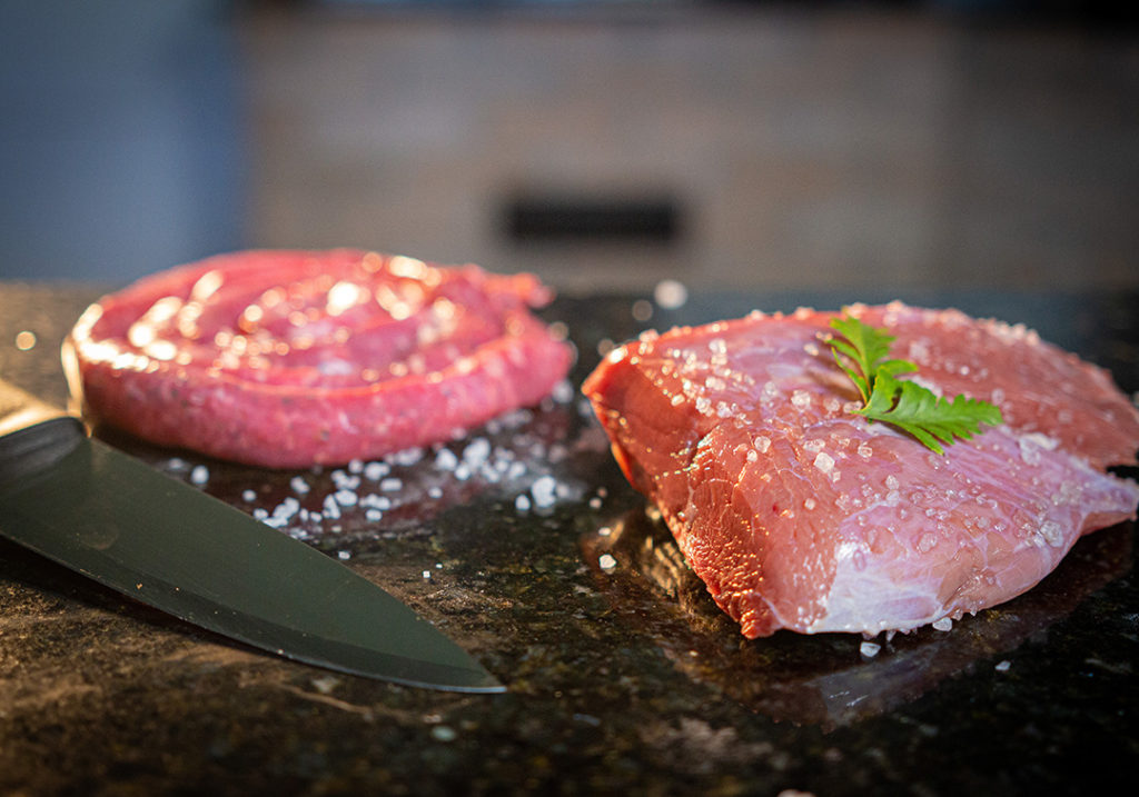 linguiça e carne de churrasco sobre uma mesa e cobertos com sal grosso