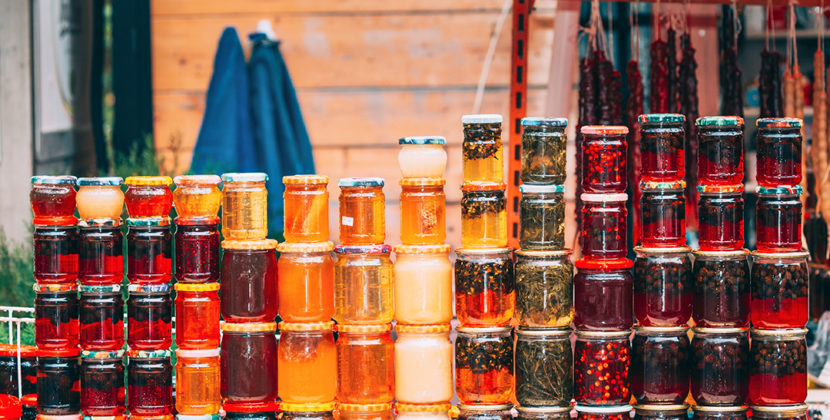 Fotografia de um conjunto de frascos de geleias e compotas, representando a fabricação de produtos tradicionais.