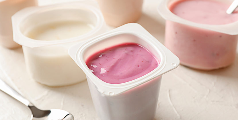 Fotografia de um grupo de embalagens plásticas de iogurte em coloração rosa, representando os diversos modelos, sabores e embalagens disponíveis à produção do iogurte brasileiro.