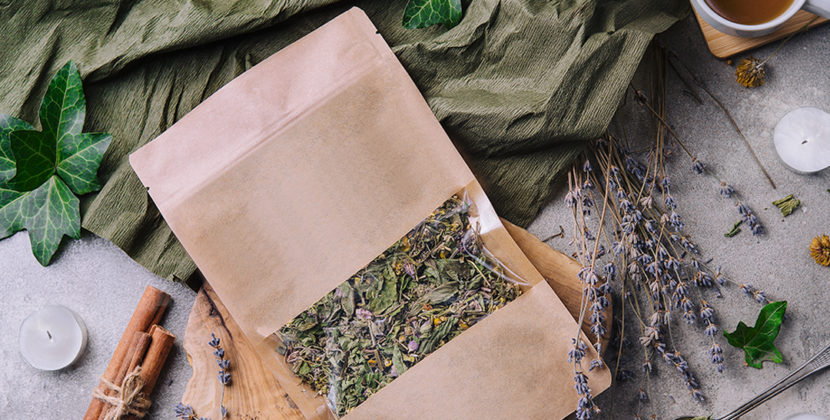 Fotografia de um pacote de chá com folhas e raízes ao redor, demonstrando a possibilidade de desenvolver uma linha de produção de chá com a embalagem ideal para o mercado nacional