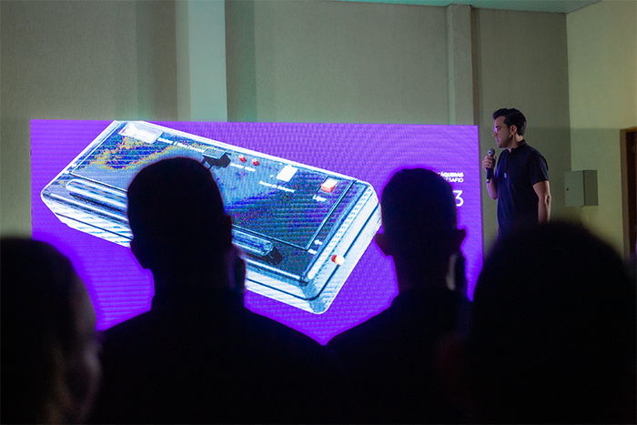 Foto de Leonardo Mello, CEO da empresa, ao lado de um registro da primeira Seladora a Vácuo da Cetro, exibido em um painel digital no evento de lançamento da CetroX.