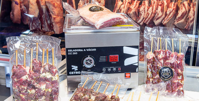: Fotografia de um balcão de açougue com iluminação e foco nas carnes apresentadas.