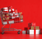 Fotografia de um carrinho de compras repleto de caixas de presentes, representando as oportunidades do mercado de final de ano.
