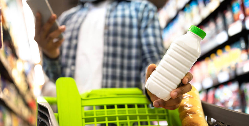Foto de um homem segurando uma garrafa de leite, representando as oportunidades do mercado de embalagens individuais.