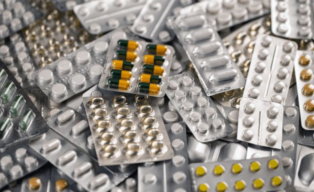 Fotografia de embalagens blister de comprimidos e cápsulas representando a indústria da saúde.
