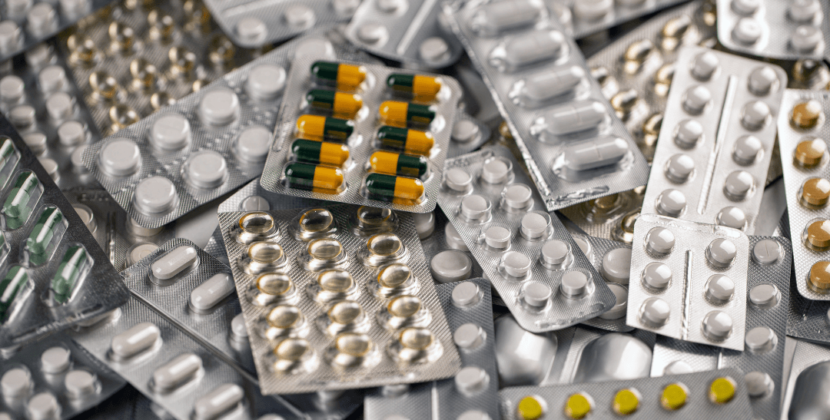 Fotografia de embalagens blister de comprimidos e cápsulas representando a indústria da saúde.
