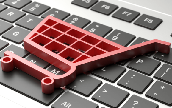 Símbolo de um carrinho de compras em cima de um teclado, representando o mercado de lojas online e e-commerce.