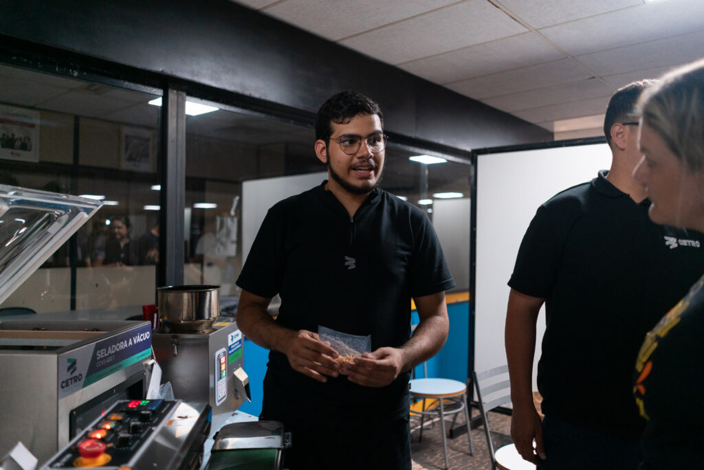 Fotografias dos colaboradores conversando com estudantes no estande da Cetro na Feira da Empregabilidade do UNISAGRADO.