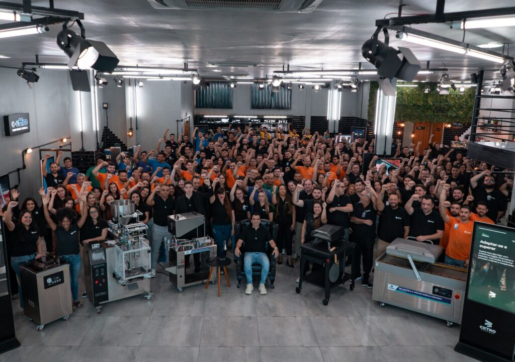 Fotografia de toda a equipe Cetro reunida no Showroom e levantando os braços.