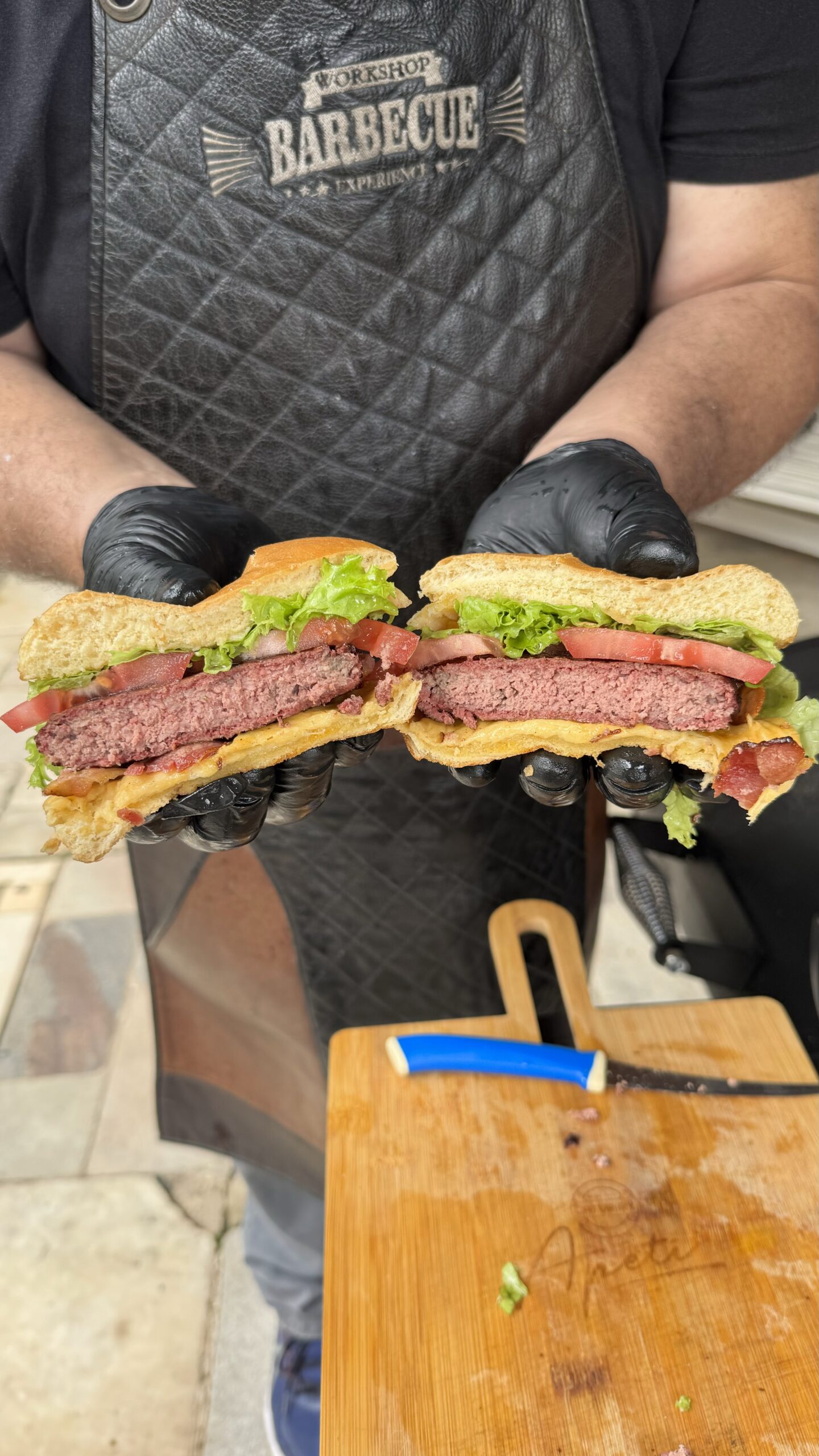 Fotografia de hambúrgueres sendo feitos na grelha do Defumador e Churrasqueira Charbroil Offset Smoker da Cetro.