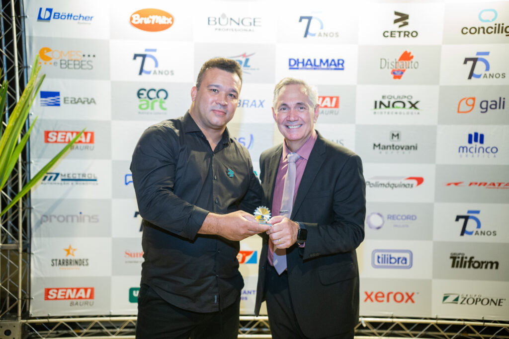 Fotografias dos colaboradores da Cetro convidados e do Diretor do SENAI Bauru entregando o troféu para um deles.