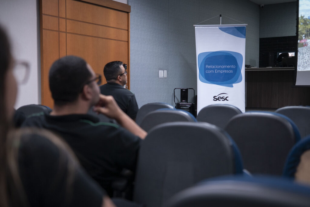 Colaboradores da Cetro assistindo à apresentação dos serviços do Sesc no auditório da Matriz.