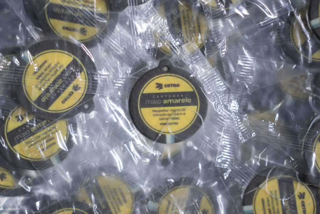 Fotografias do palestrante com o Técnico de Segurança do Trabalho da Cetro no auditório da Matriz e dos brindes da Campanha Maio Amarelo.