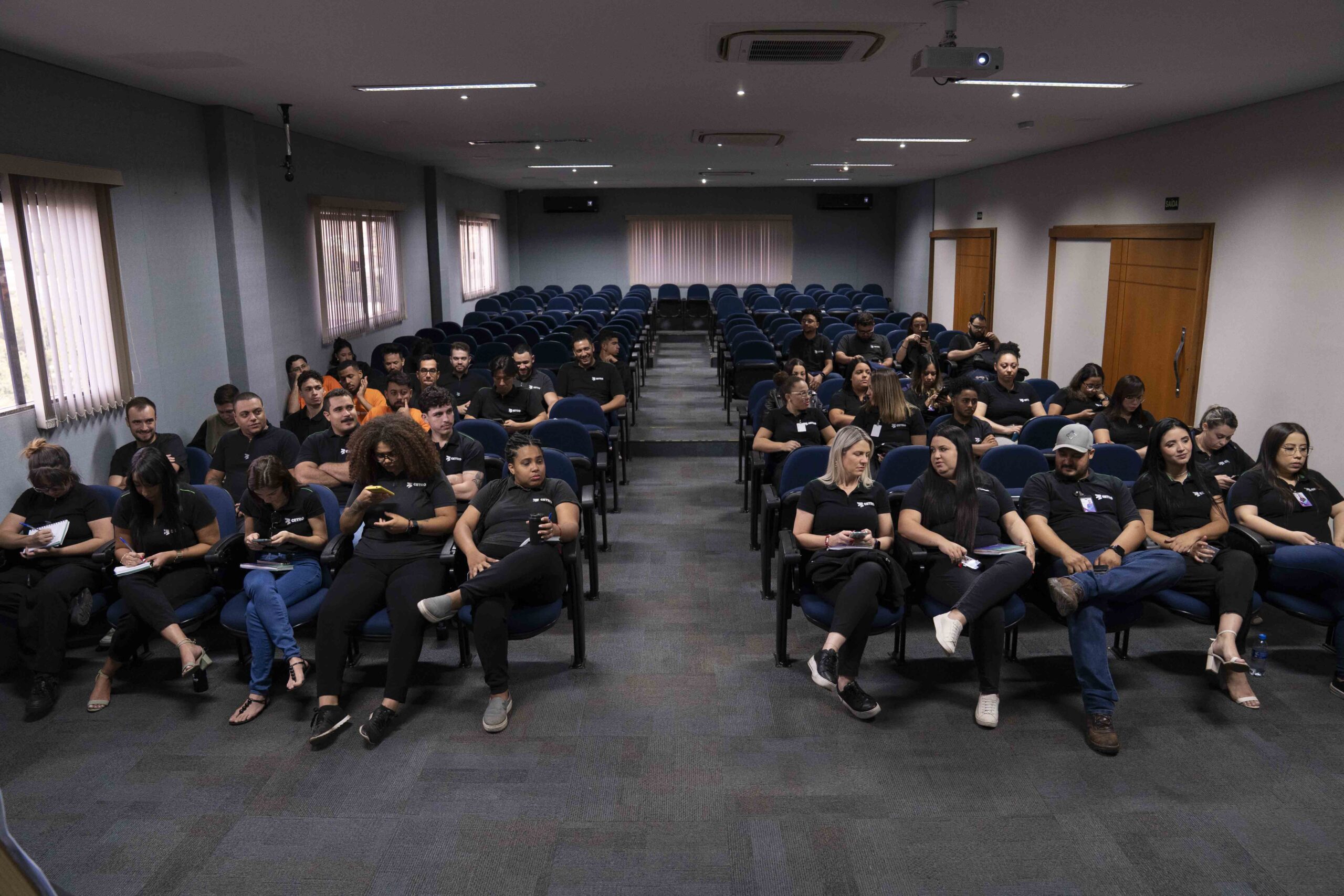 Fotografia das apresentações e dos colaboradores assistindo aos treinamentos.