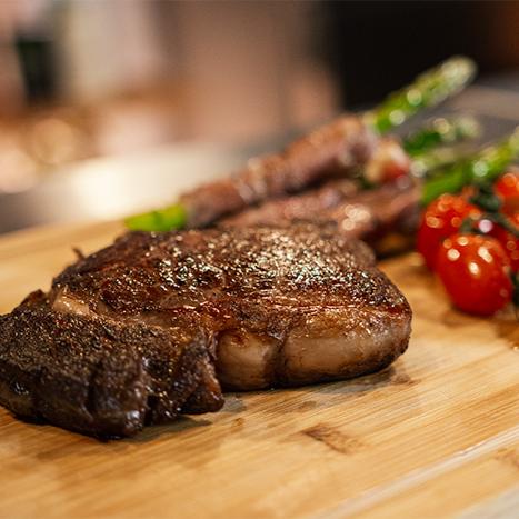 Fotografia de carnes preparadas no Termocirculador Sous Vide e na Seladora Suprême Vac Slim realizando o vácuo em uma embalagem com uma bisteca, representando seu uso em hamburguerias.
