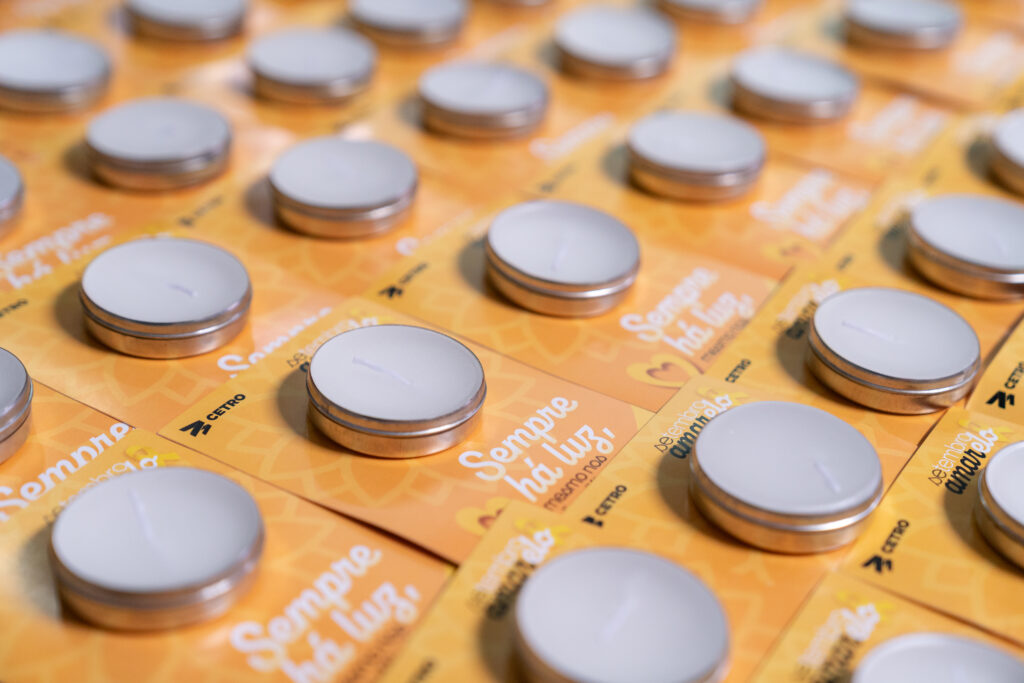 Fotografias dos balões amarelos da dinâmica da Campanha de Setembro Amarelo, de um colaborador estourando um balão e das velas aromáticas.