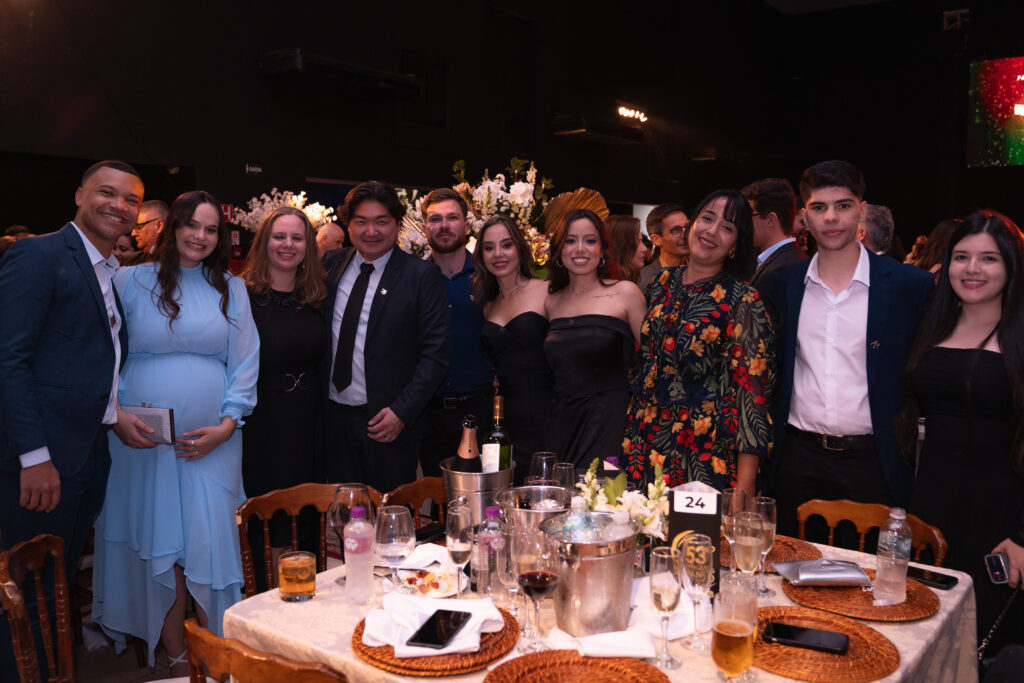 Fotografias da família de Léo Mello recebendo o prêmio no palco e dos colaboradores da Cetro e seus cônjuges que compareceram ao evento.
