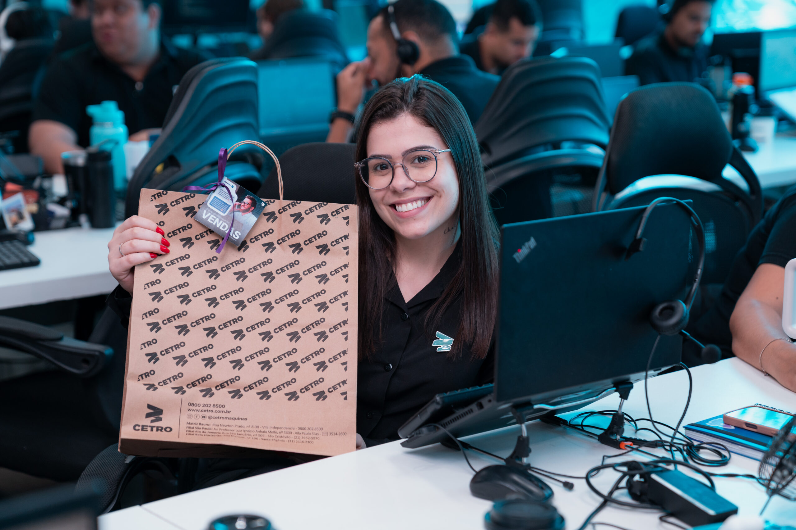 Fotografias das colaboradoras das equipes comerciais Cetro segurando as sacolas de brindes comemorativos ao Dia do Profissional de Vendas.