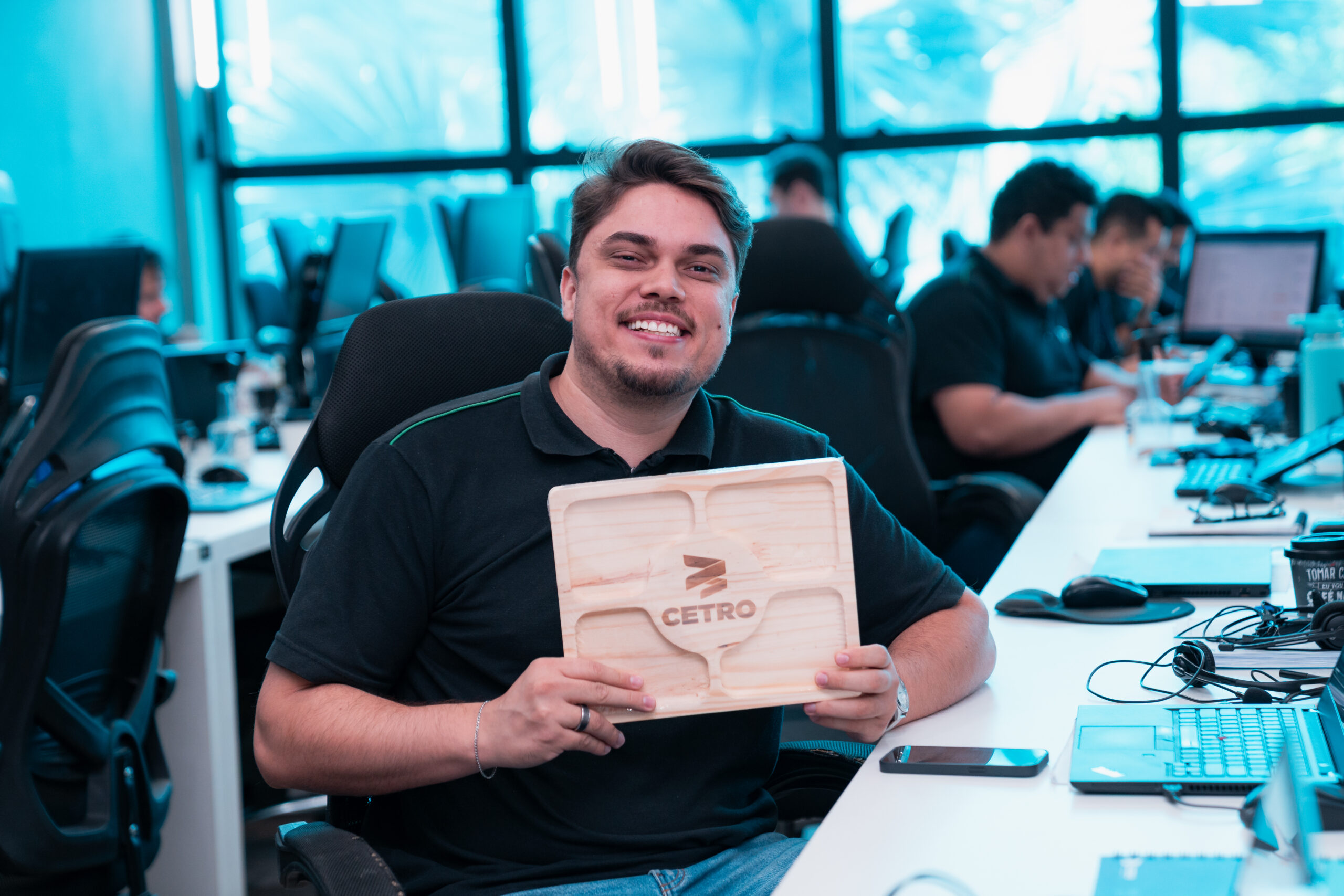 Fotografia dos colaboradores segurando a petisqueira e as sacolas do brinde comemorativo ao Dia do Profissional de Vendas.