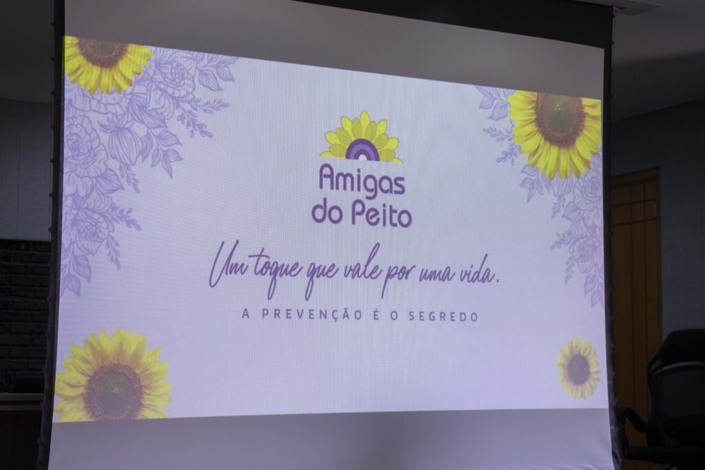 Fotografia dos brindes da palestra e de um slide com a mensagem “Um toque que vale por uma vida”.