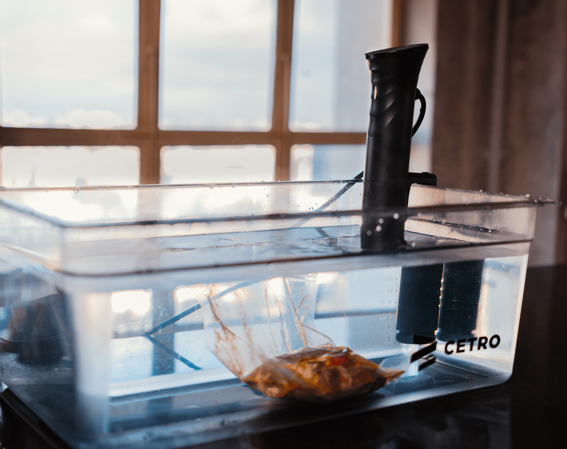 Fotografias da Seladora a Vácuo Suprême Vac CCVS S-300 M, de uma embalagem em processo de vácuo e do Termocirculador CSVC 84 em uma cuba com água e uma embalagem a vácuo, produtos em promoção na Black Friday.