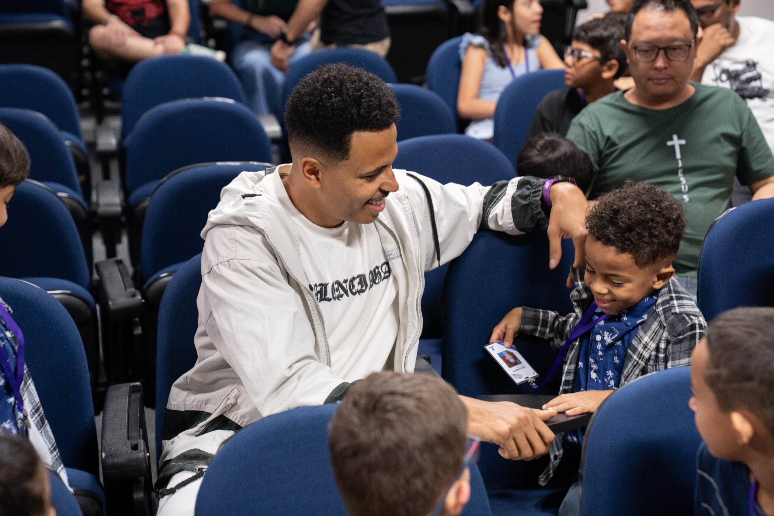 Fotografias dos colaboradores da Cetro e seus filhos no Auditório Ayrton Senna para a abertura do Cetro Fun Day, e das crianças brincando com o Cyberdog.