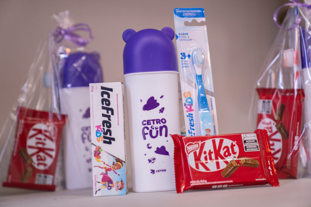 Fotografias dos brindes do Cetro Fun Day e das crianças os recebendo.