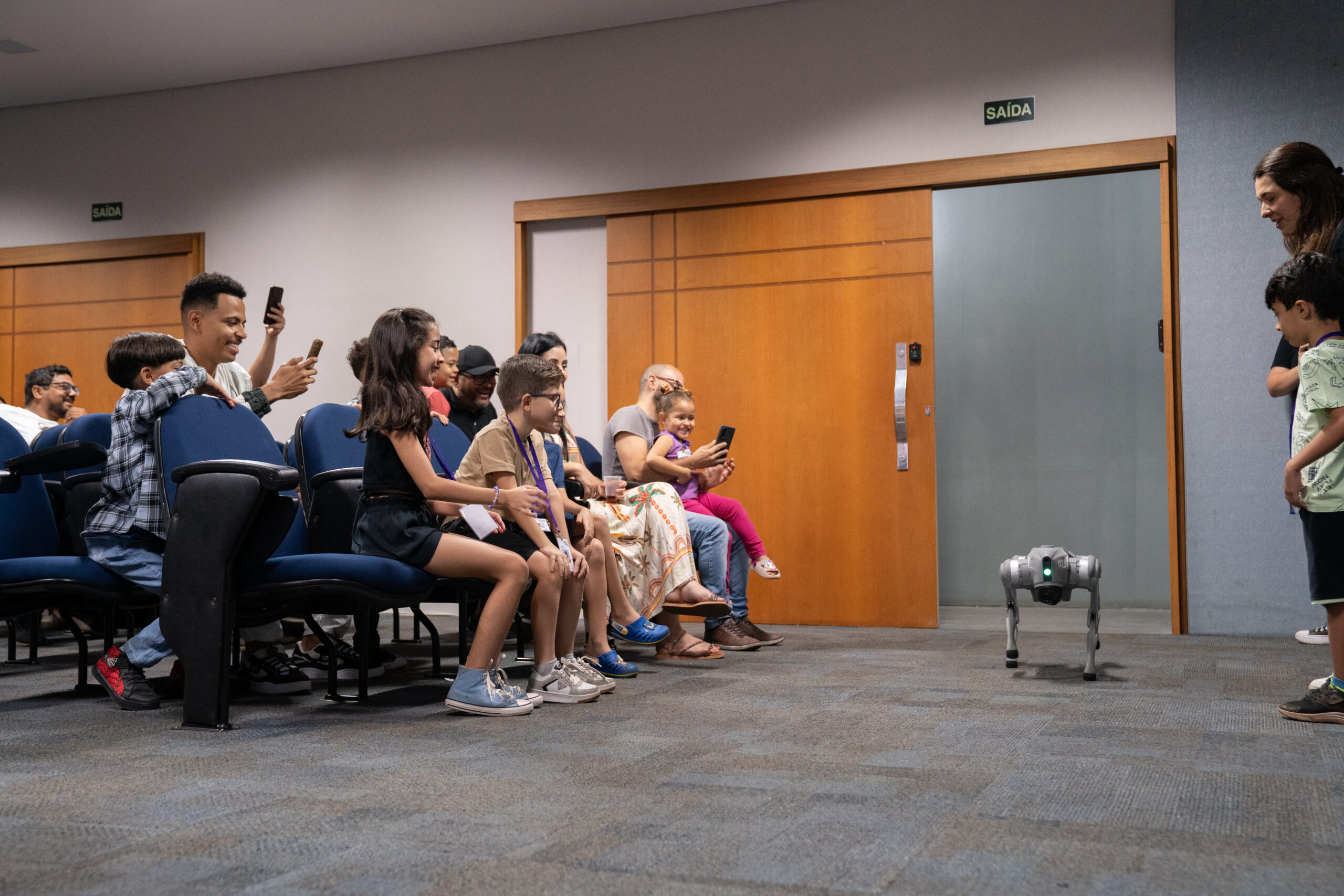 Fotografias dos colaboradores da Cetro e seus filhos no Auditório Ayrton Senna para a abertura do Cetro Fun Day, e das crianças brincando com o Cyberdog.