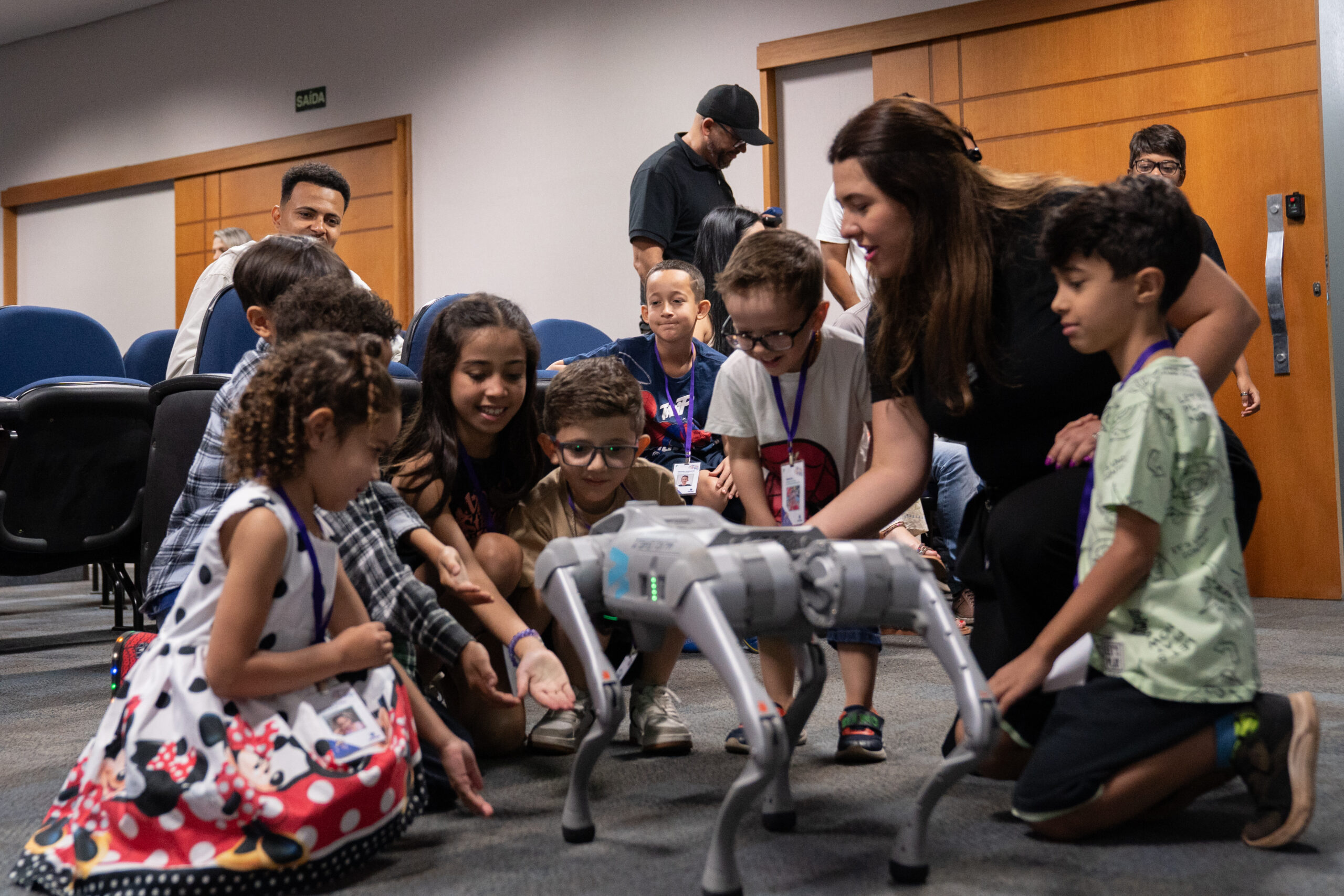 Fotografias dos colaboradores da Cetro e seus filhos no Auditório Ayrton Senna para a abertura do Cetro Fun Day, e das crianças brincando com o Cyberdog.