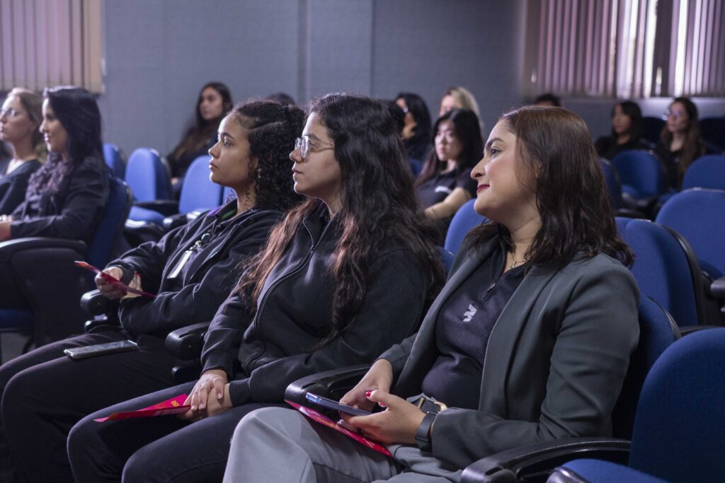 Fotografia dos colaboradores da Cetro assistindo à palestra sobre Outubro Rosa e das representantes do Grupo Amigas do Peito mostrando o modelo didático “Mamamiga”.