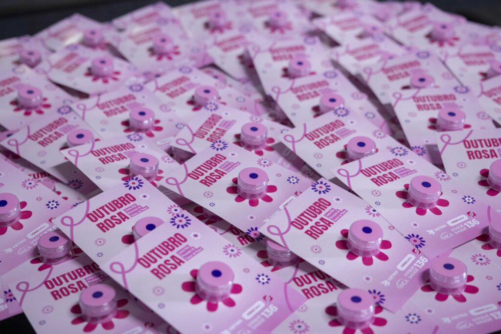 Fotografia dos brindes da palestra e de um slide com a mensagem “Um toque que vale por uma vida”.