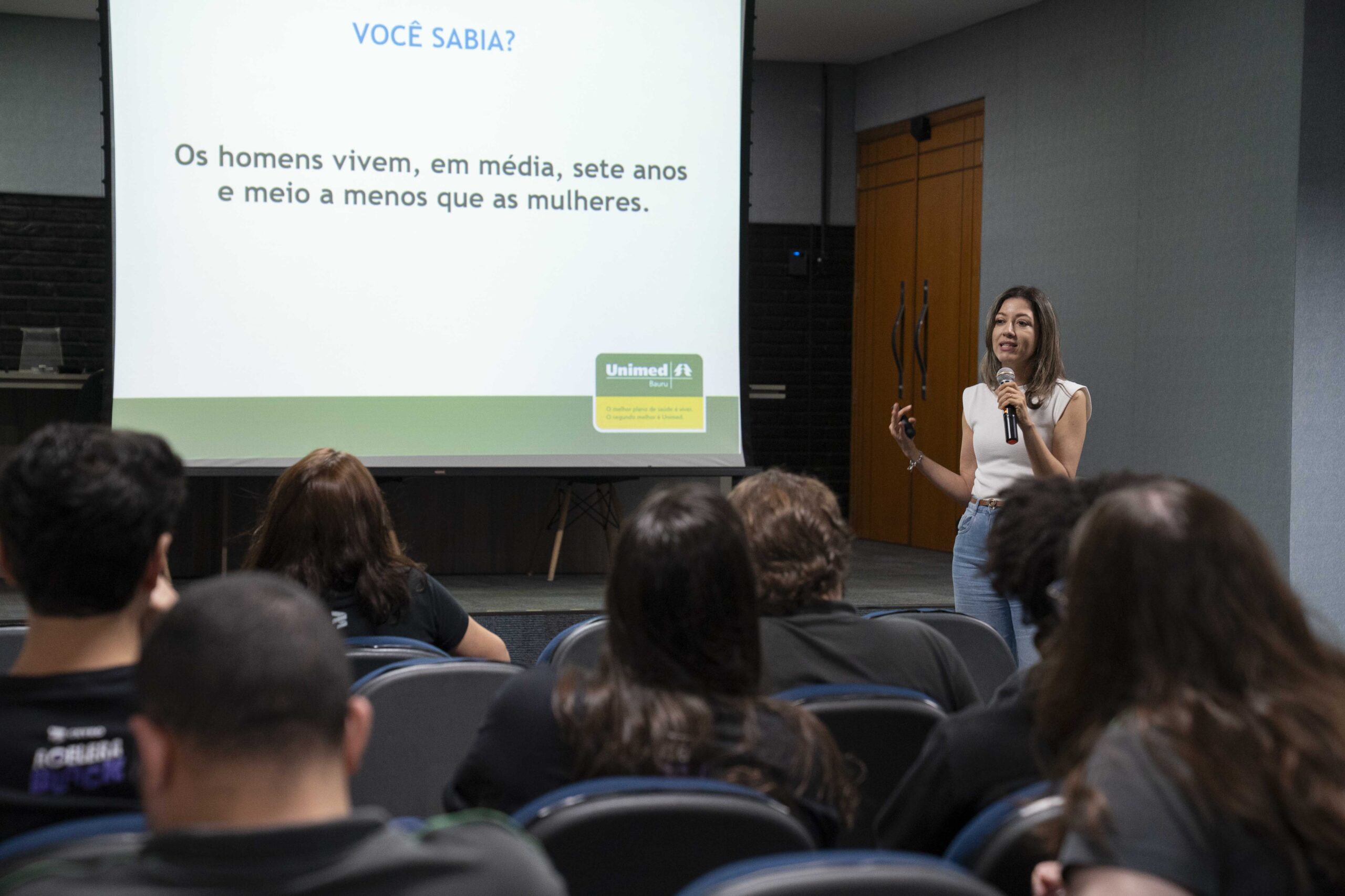 Fotografias dos colaboradores da Cetro assistindo à palestra sobre Novembro Azul e da palestrante.