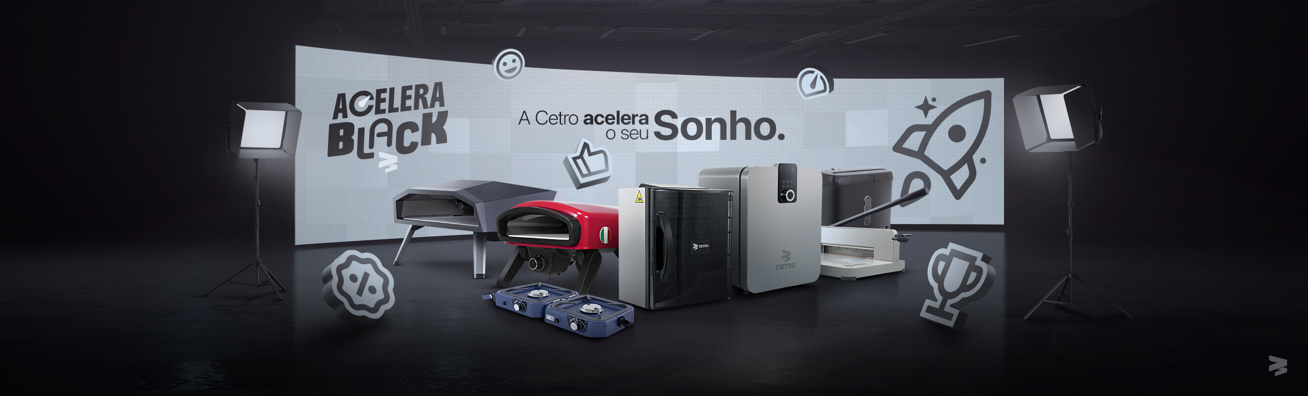 Banner da campanha Acelera Black 2025 com imagens de alguns maquinários em um estúdio escuro com luminárias, emojis e a frase “A Cetro acelera o seu sonho” no centro.