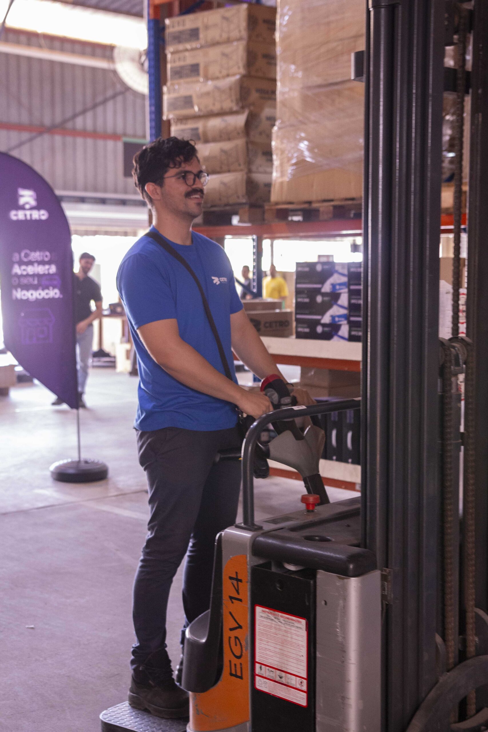 Fotografias da equipe logística da Cetro e de banners da campanha Acelera Black 2025 no Centro de Distribuição da companhia.