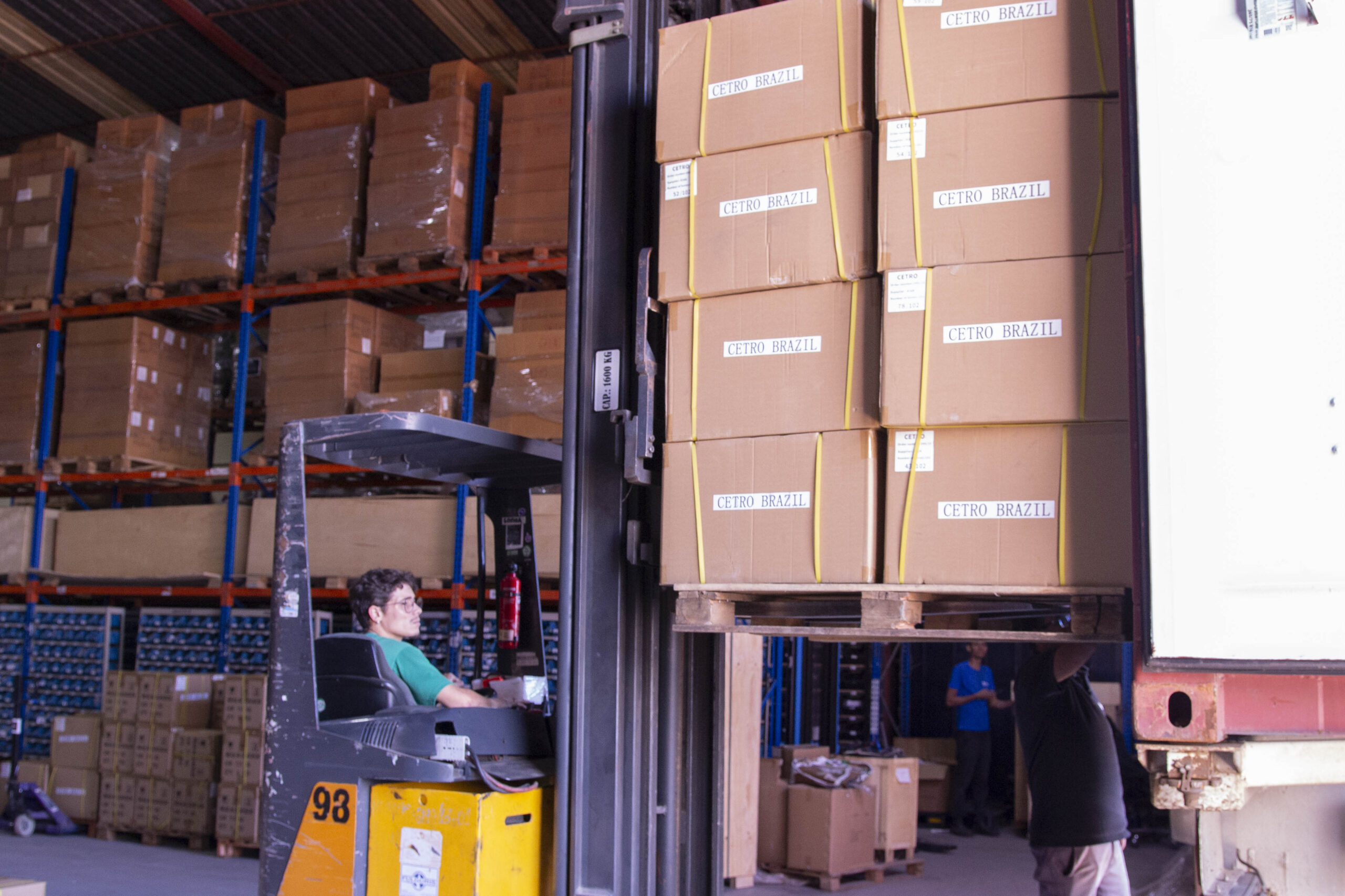 Fotografias da equipe logística da Cetro e de banners da campanha Acelera Black 2025 no Centro de Distribuição da companhia.