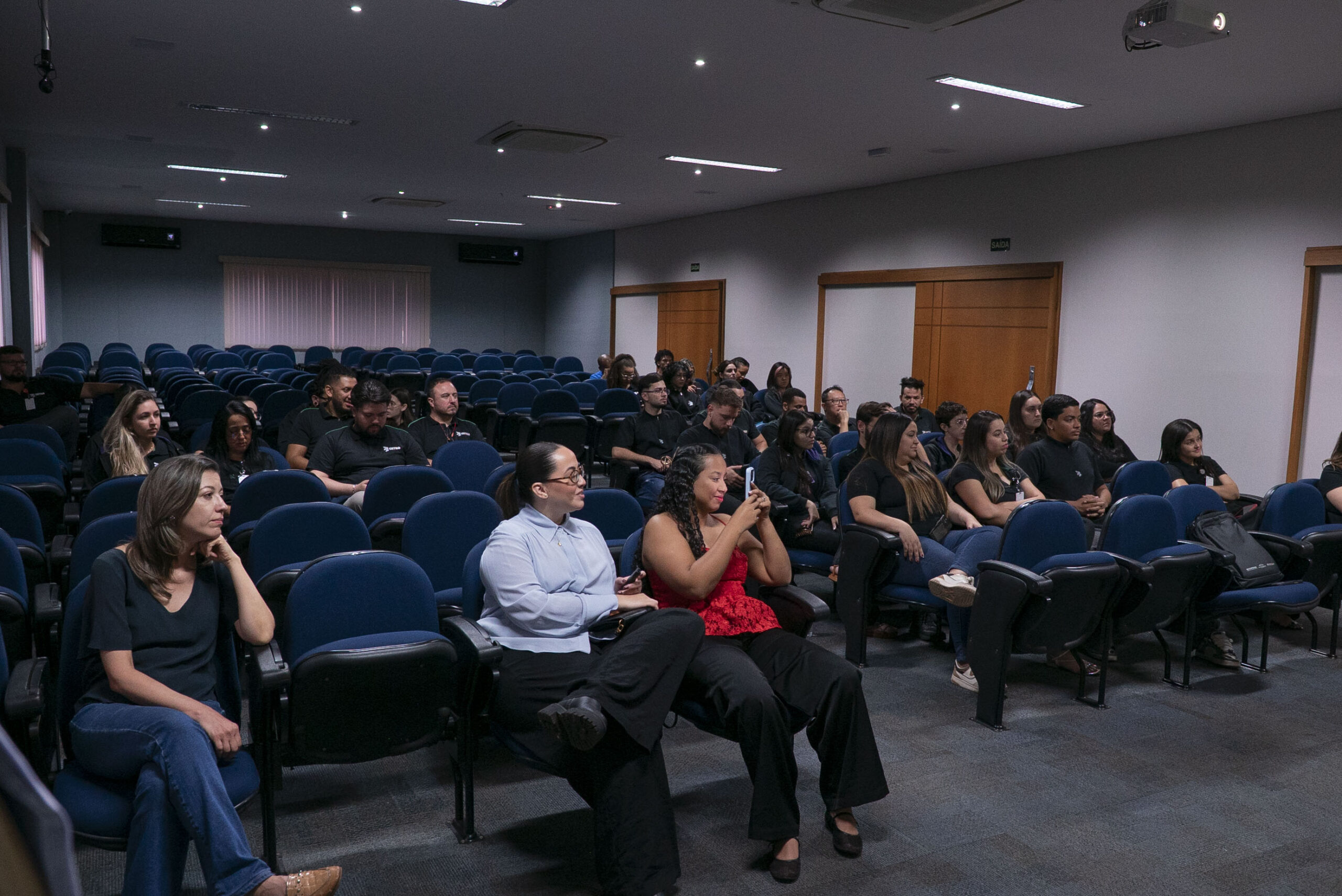 Fotografia do representante da Bioderma apresentando a marca e dos colaboradores assistindo.