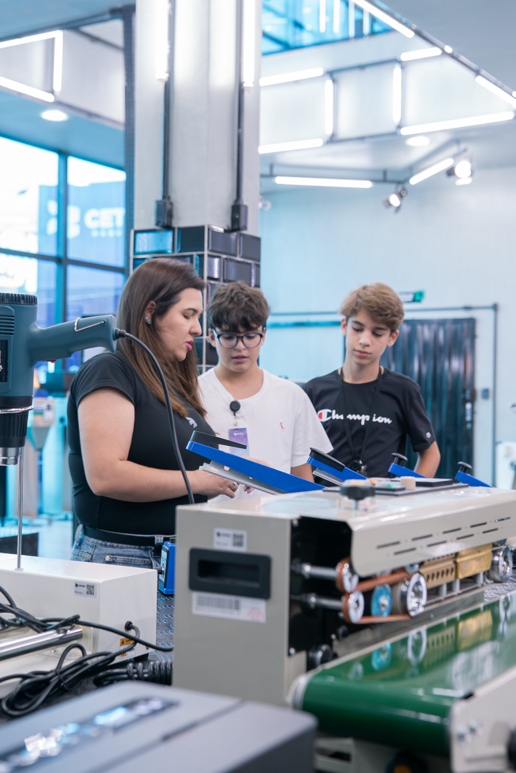 Fotografias da Gabriela Oliveira explicando sobre os maquinários para os alunos e dos alunos aproveitando o tour.