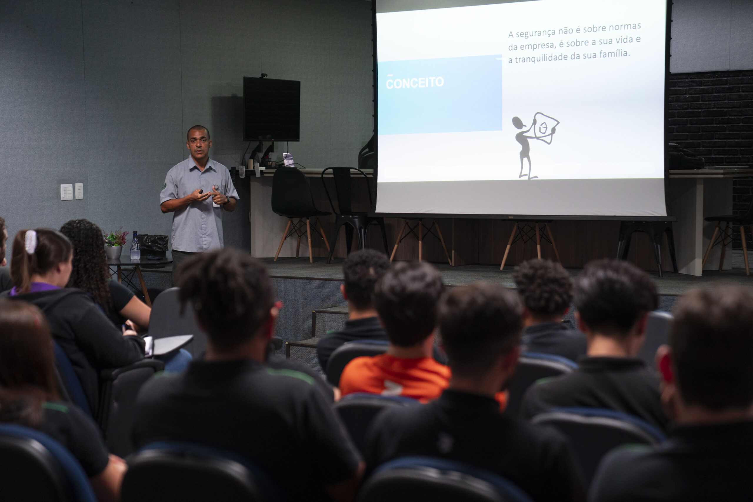 Fotografias do palestrante durante a apresentação sobre segurança do trabalho e dos colaboradores assistindo.