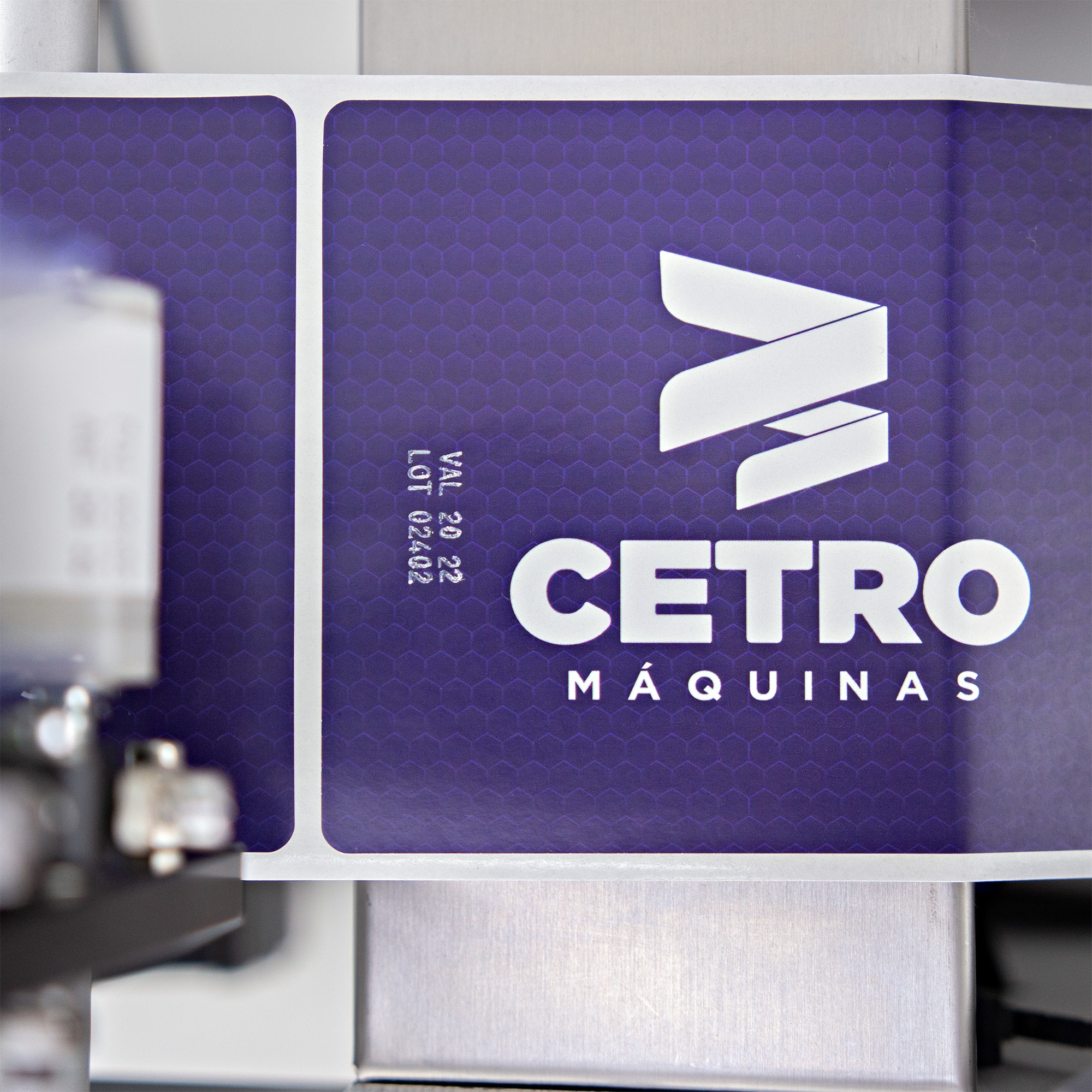 Fotografias de adesivos roxos com o logotipo da Cetro, com informações impressas pelo datador de termotransferência da Rotuladora Semiautomática com Datador CSLM DP.