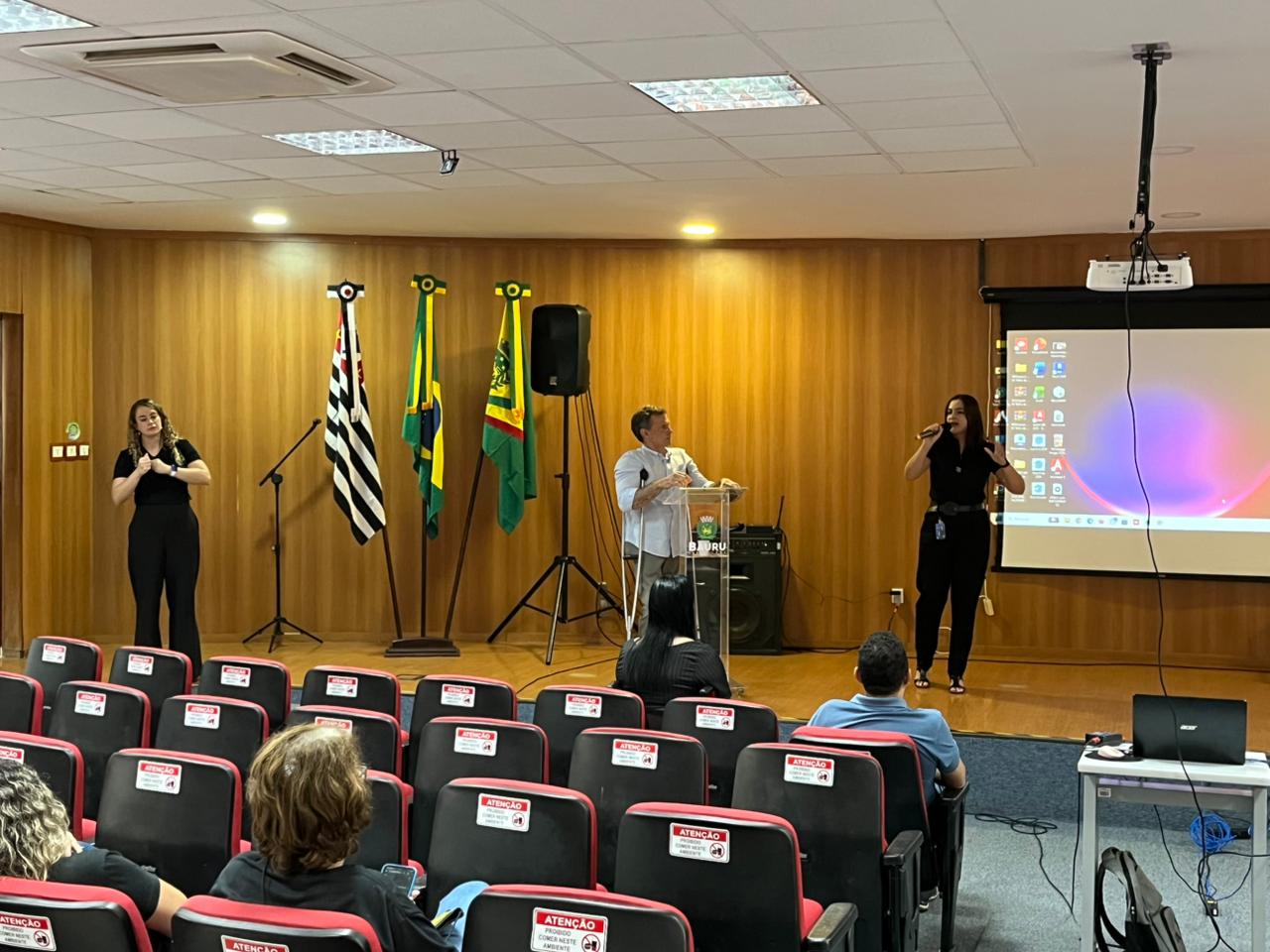 Fotografias da Head de Gente e Gestão da Cetro apresentando a companhia durante o evento da Semana de Conscientização do TEA.