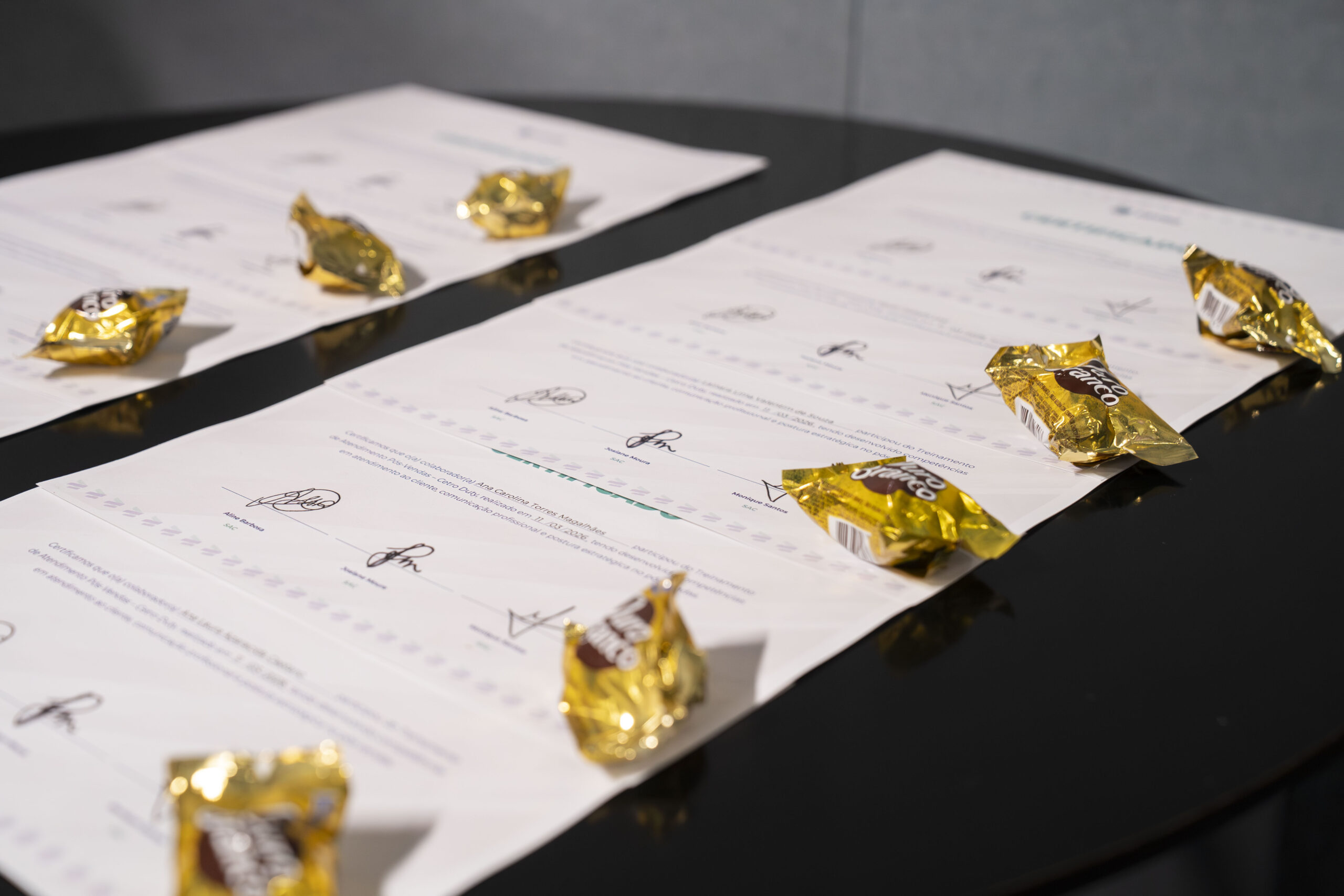 Fotografia dos colaboradores segurando seus certificados de participação no treinamento.