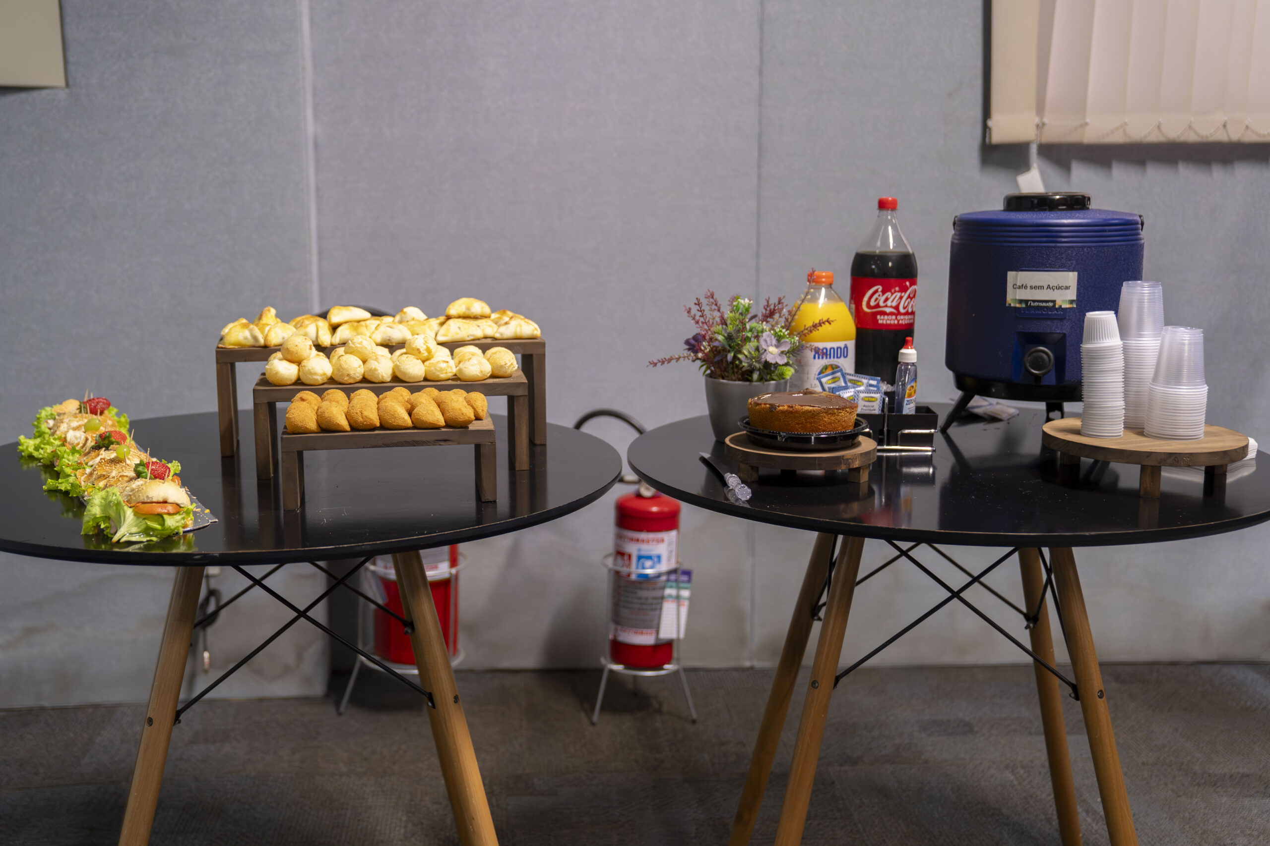 Fotografias dos alimentos expostos na mesa para o coffee break e de uma colaboradora Cetro em frente ao telão de apresentação do treinamento.
