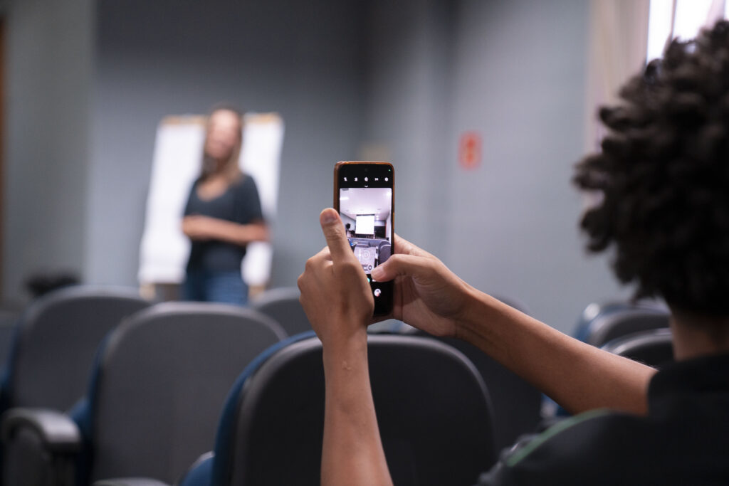 Fotografia de um colaborador na palestrante da Campanha Abril Marrom na Cetro tirando uma foto para participar do sorteio.