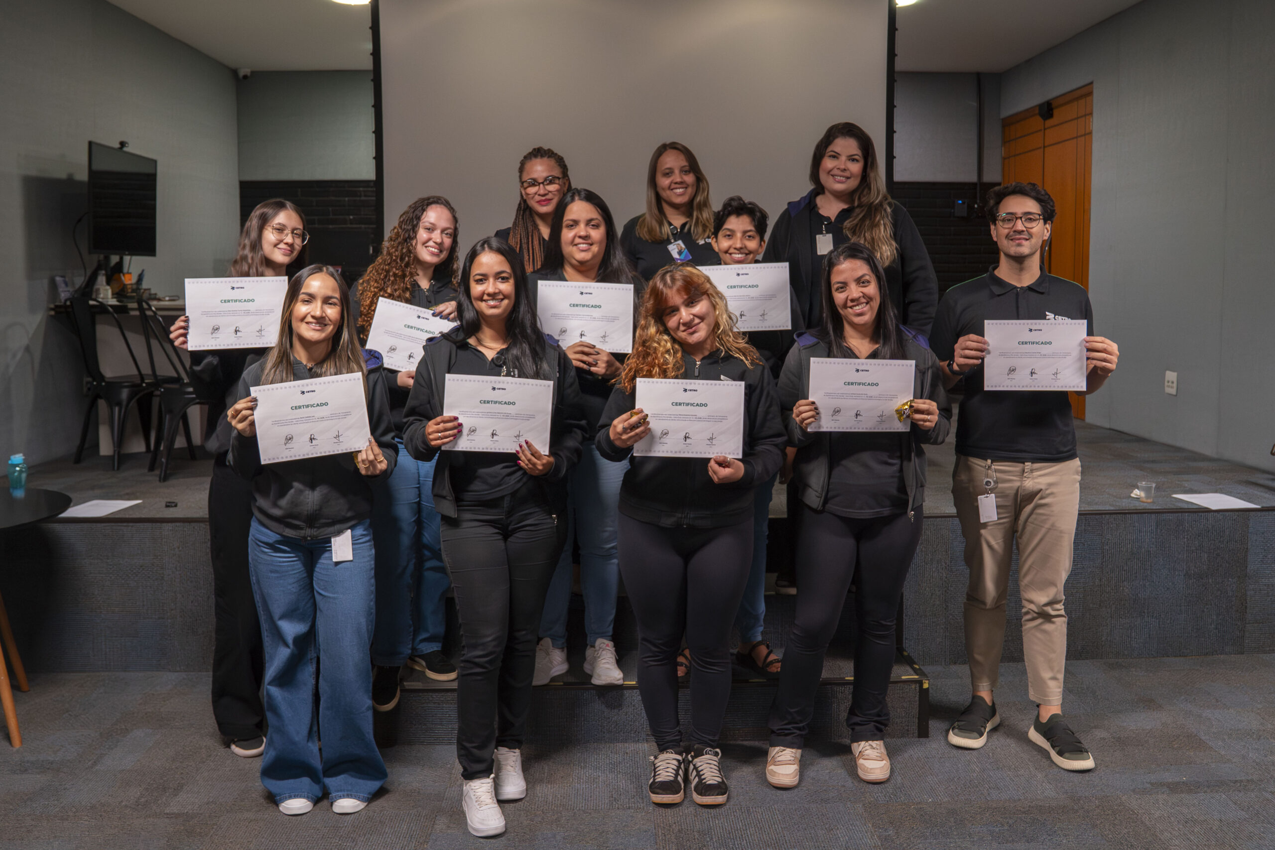 Fotografia dos colaboradores segurando seus certificados de participação no treinamento.