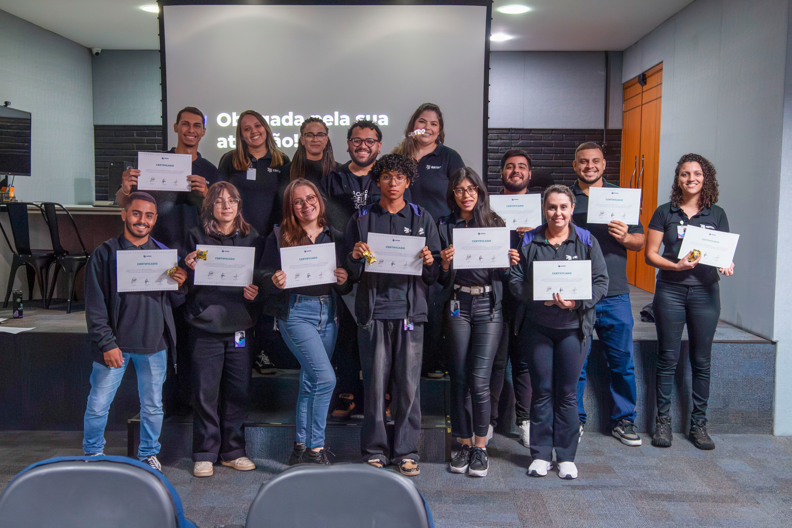 Fotografia dos colaboradores segurando seus certificados de participação no treinamento.